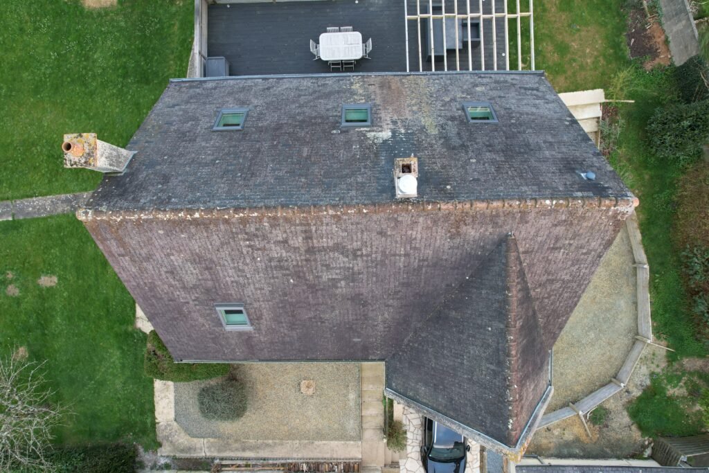 Avant traitement : toiture en ardoise naturelle vue drone, lichens et mousses — Bretagne